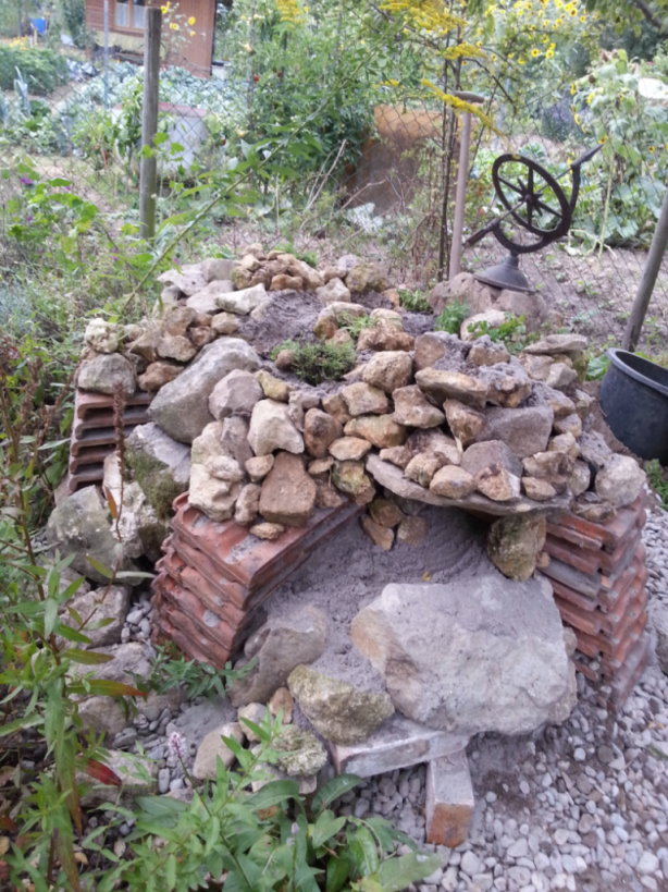 Auch ein Sandarium darf hier nicht fehlen. Darin fängt sich die Sonnenwärme und es ist ein perfektes Refugium für Eidechsen, aber auch Nistmöglichkeit für verschiedene Wildbienen. Denn 50 Prozent der Wildbienen, die in Deutschland, Österreich und der Schweiz heimisch sind, nisten im Erdboden! Deshalb folgt noch ein weiteres Bauwerk in kürze und ganz in der Nähe der Eidechsenburg...